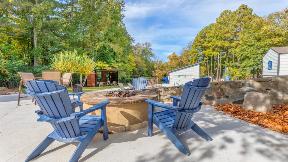 a patio with two blue chairs and a fire pit at The  Bowie